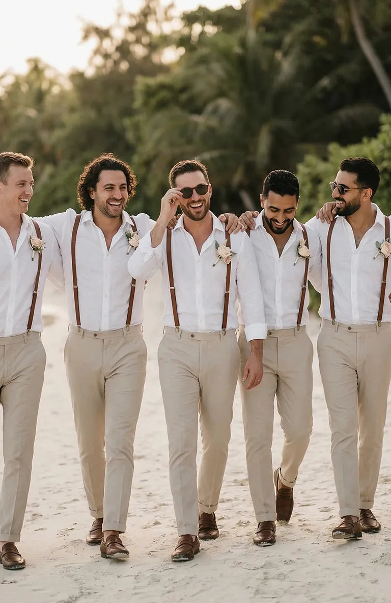 Five men in white shirts and Men's Verona Linen Pants in Natural with suspenders walking on a beach.